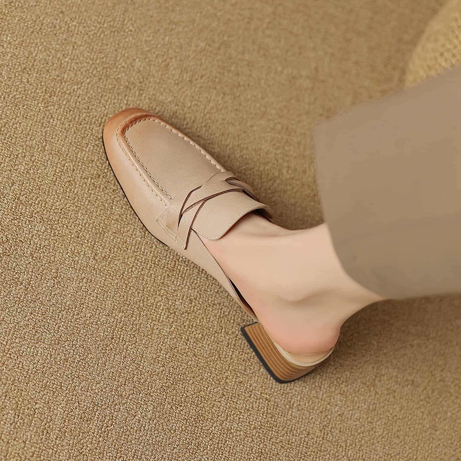 A stylish beige loafer shoe worn by a woman, showcasing comfort and elegance, perfect for professional, casual, or fashionable everyday outfits. Ideal footwear for those seeking a blend of style and comfort.
