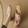 Close-up of stylish nude leather loafers displayed on a beige textured surface, showcasing handcrafted design and comfort, perfect for fashionable women seeking premium footwear.