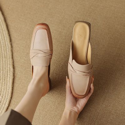 Close-up of stylish nude leather loafers displayed on a beige textured surface, showcasing handcrafted design and comfort, perfect for fashionable women seeking premium footwear.