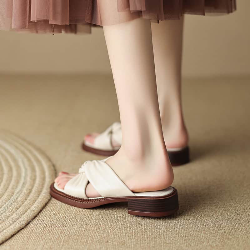 Comfortable beige slip-on sandals with chunky wooden heels, perfect for stylish occasions and casual wear.