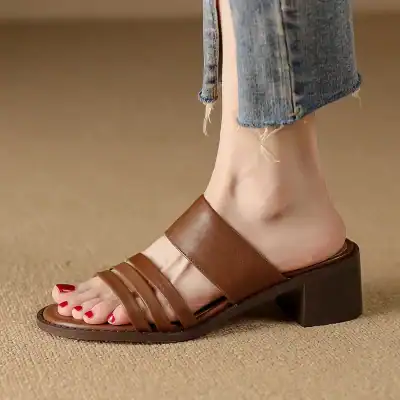Elegant brown leather slip-on sandal with a block heel, perfect for stylish and comfortable footwear. Ideal for casual and semi-formal occasions.