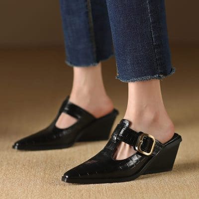 Stylish women's black wedge heels with buckle detail, perfect for fashion-forward looks and comfortable wear. Ideal for casual or dressy occasions, combining style and comfort effortlessly.