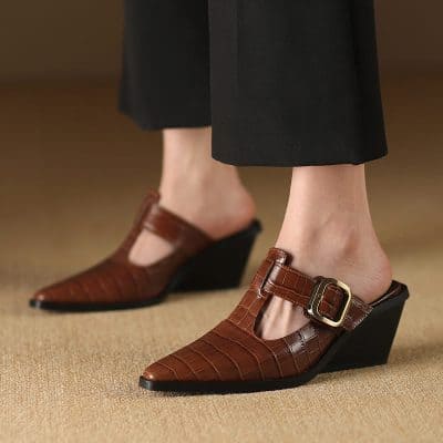Stylish women's brown leather wedge shoes featuring a crocodile print, pointed toe, and ankle strap with gold buckle for a fashionable look.