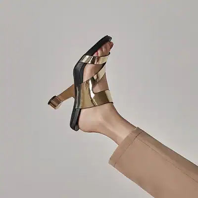 Elegant gold and black high heel sandals showcased with a modern design, perfect for fashion-forward women seeking luxury footwear options.