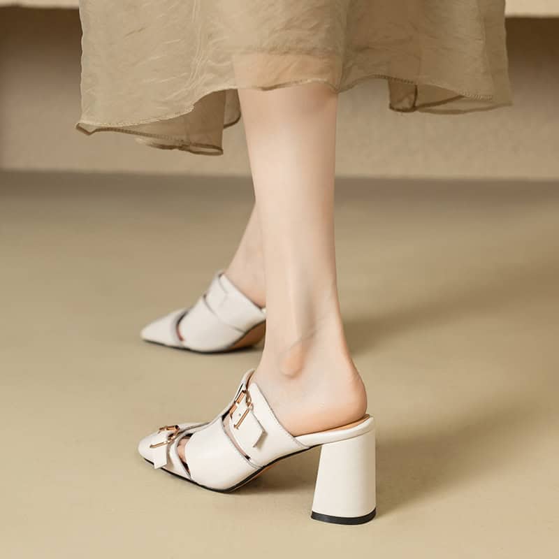 Elegant white high-heel mules with buckle detail, perfect for fashion-forward women seeking comfort and style. Ideal for casual outings or dressy occasions.