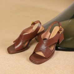 Women’s designer brown leather block heel sandals with crisscross straps and adjustable ankle strap for comfort. Perfect for fashion-forward occasions.