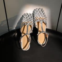 Stylish silver open-toe sandals with intricate lattice design and adjustable ankle strap, perfect for trendy fashion and special occasions.