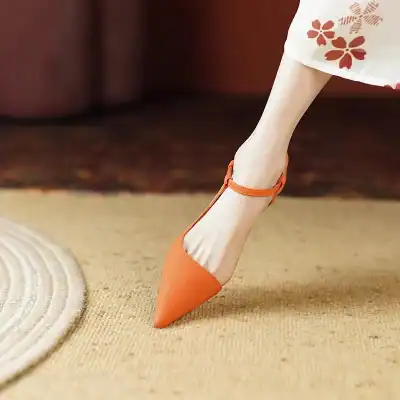 Elegant orange high heel shoe with ankle strap, perfect for fashionable women's footwear and stylish dress shoes.