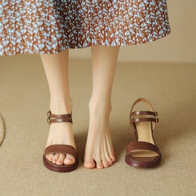 Elegant brown sandals displayed on a woman's feet with one shoe off, showcasing stylish footwear options available at Monalisa Store for women’s fashion and comfortable shoes.