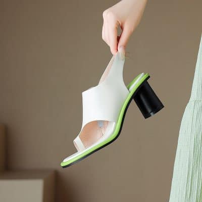Elegant white high heel shoe with black heel and green sole, showcasing trendy footwear design. Perfect for fashion-forward women seeking stylish and comfortable shoes.