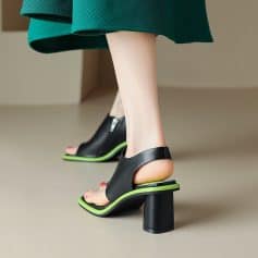 Fashionable high heel sandals with unique cut-out design, black color with neon green accents, perfect for modern footwear styles and statement summer outfits.