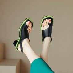 Stylish black and green designer sandals with open toes and zipper details, perfect for casual or chic summer outfits.