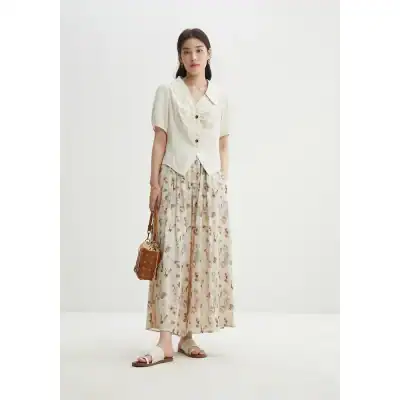 Photo of a stylish woman wearing flowy floral pants, a light blouse, and accessories, showcasing trendy women's clothing from Monalisa Store. Perfect for fashion-forward looks and accessories.