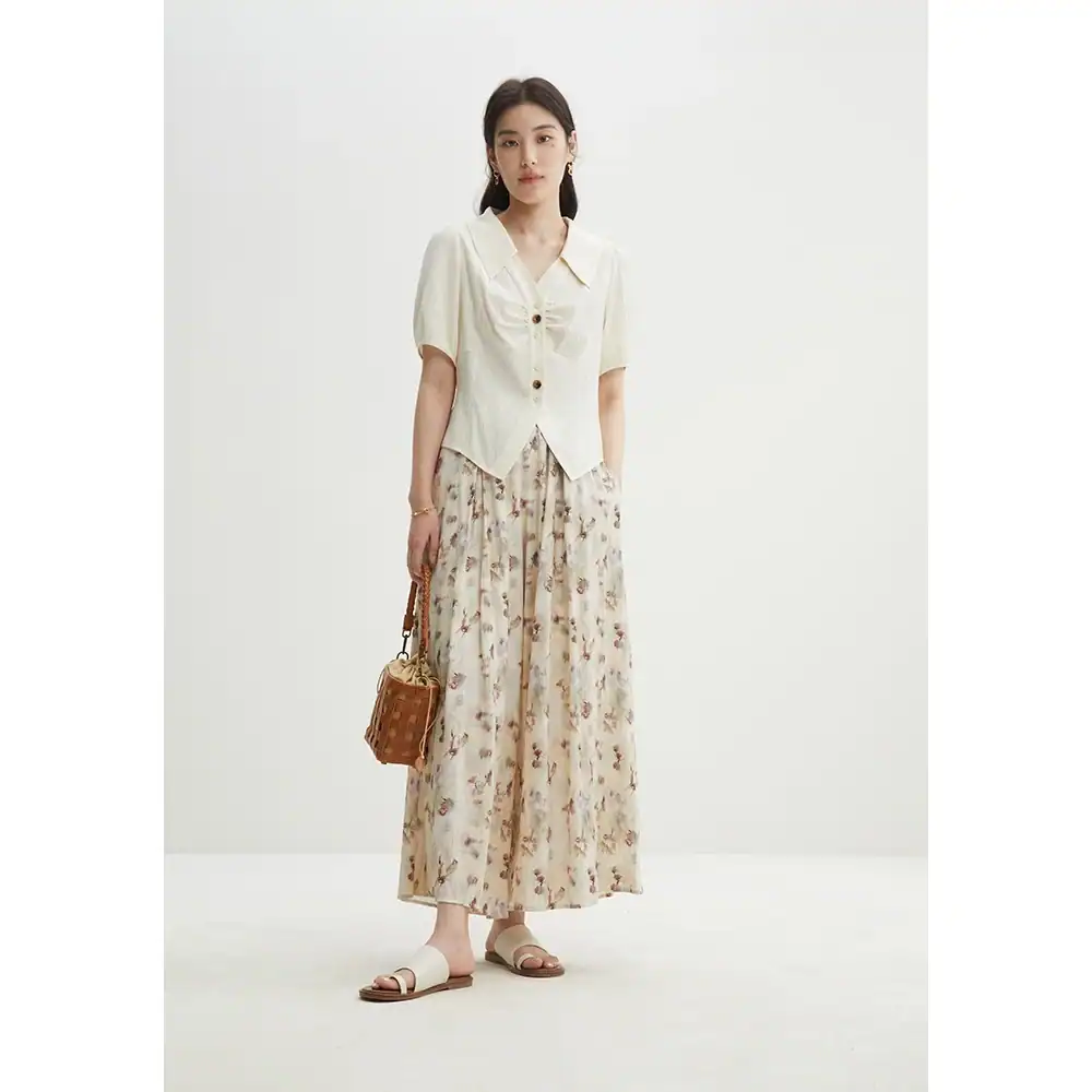 Photo of a stylish woman wearing flowy floral pants, a light blouse, and accessories, showcasing trendy women's clothing from Monalisa Store. Perfect for fashion-forward looks and accessories.