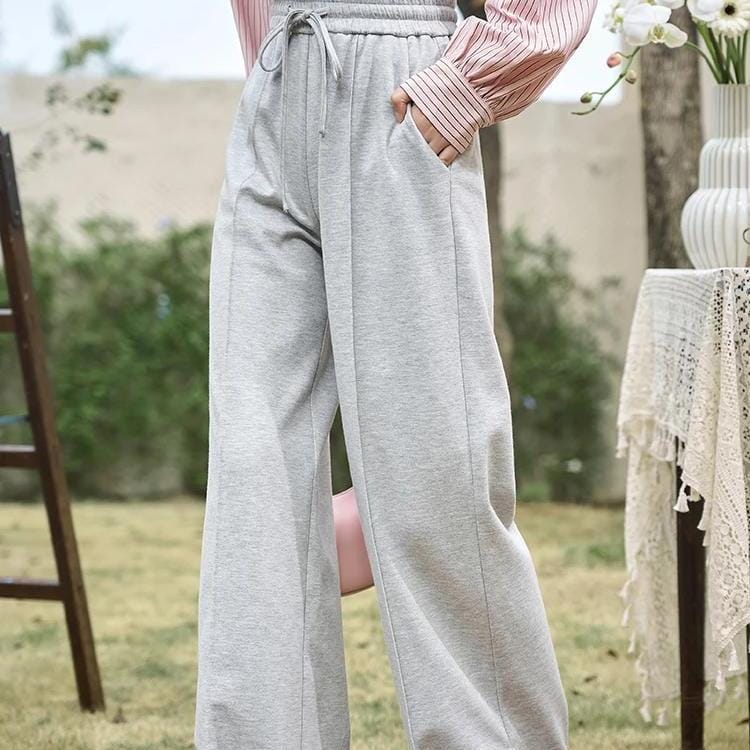 Comfortable women's lounge pants made from soft gray fabric, featuring an elastic waistband with a drawstring for a perfect fit, ideal for relaxation and everyday casual wear.