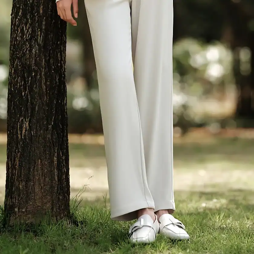 Comfortable women's white wide-leg trousers paired with stylish white loafers, perfect for casual outings or outdoor activities, emphasizing fashion and comfort.