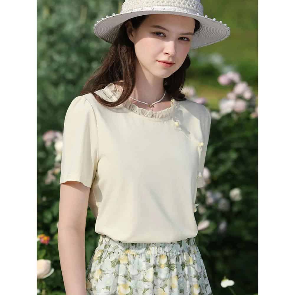 High-quality ivory women's blouse with delicate pearl accents, perfect for spring and summer casual or semi-formal wear. Designed for comfort and style, suitable for outdoor outings and garden parties.