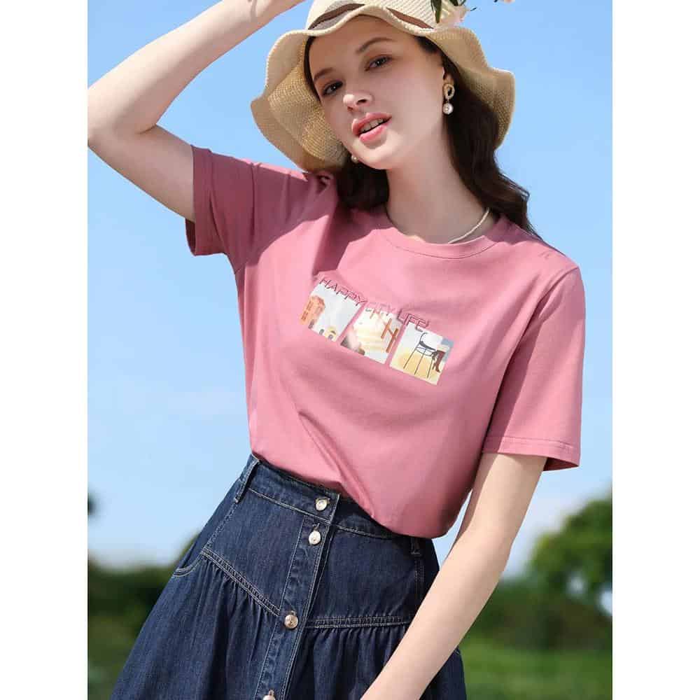 Stylish pink T-shirt featuring a graphic print, perfect for casual fashion, paired with high-waisted denim skirt. Great for summer outings or everyday wear, combining comfort and trendy style.
