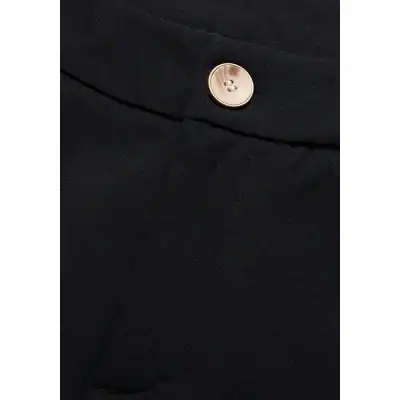 Close-up of black formal pants showcasing a silver button and tailored fabric, ideal for professional or stylish occasions.