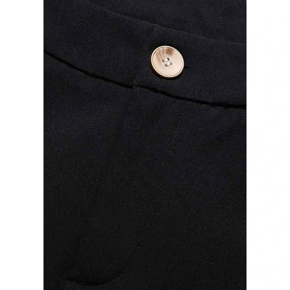 Close-up of black formal pants showcasing a silver button and tailored fabric, ideal for professional or stylish occasions.