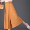 A stylish pair of orange high-waisted pleated wide-leg trousers perfect for any fashionable look. Made from comfortable fabric, ideal for casual or dressy occasions, complements various tops and footwear.
