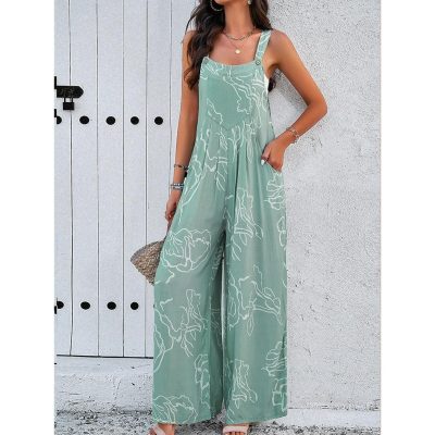 Stylish woman wearing a flowy green jumpsuit with white floral prints, sleeveless design, and wide-leg pants, ideal for summer outings or casual events.