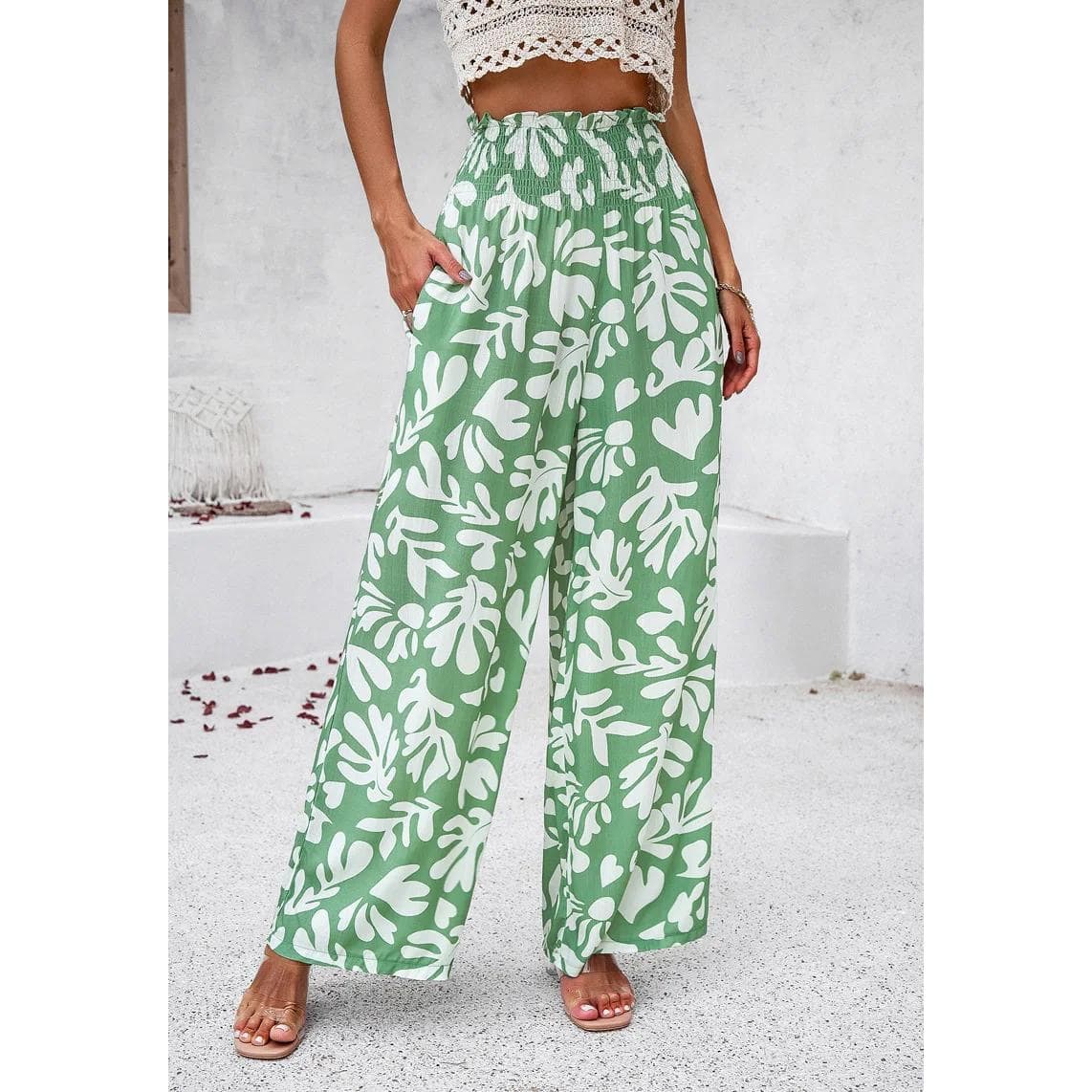 Stylish green and white wide-leg pants with a bold floral pattern, perfect for casual or beachwear, offering comfort and trendy summer style.