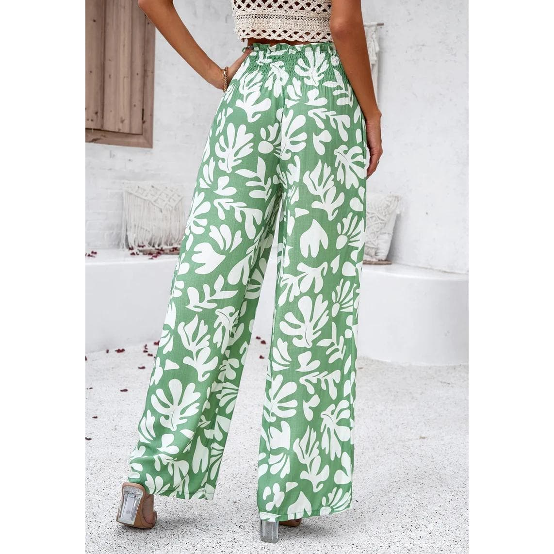 Elegant wide-leg green pants with bold white floral pattern, perfect for stylish summer wear and casual outings.