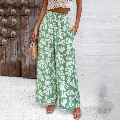 Stylish green wide-leg pants with tropical white leaf pattern, perfect for summer and resort wear, offered by Monalisa Store.