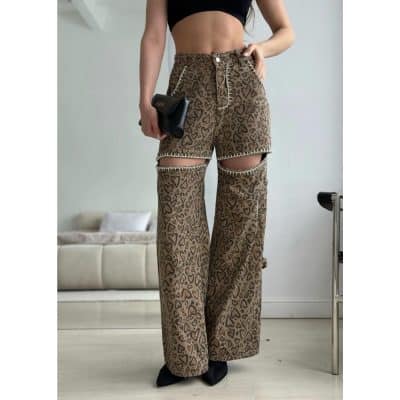 Stylish animal print wide-leg pants featuring ripped knees, decorative stitching, and a comfortable fit, paired with a black crop top for a chic and modern fashion statement.
