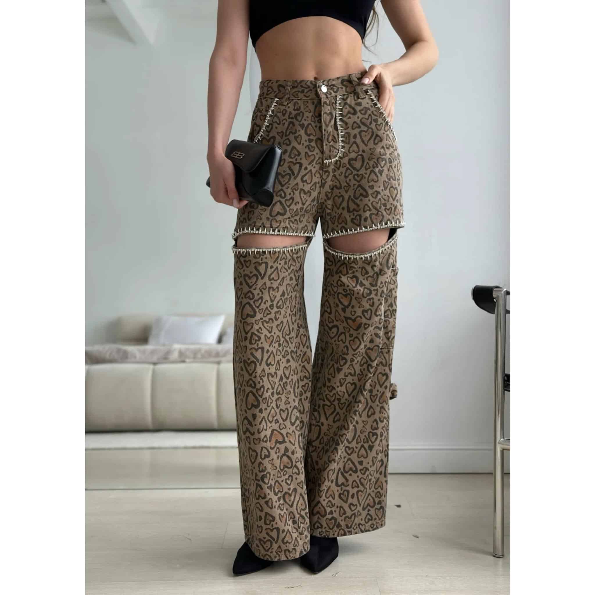 Stylish animal print wide-leg pants featuring ripped knees, decorative stitching, and a comfortable fit, paired with a black crop top for a chic and modern fashion statement.