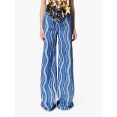 Stylish wide-leg denim pants with a vibrant blue and white wavy stripe pattern, perfect for a trendy, casual look. Comfortable fit with high waist design, ideal for fashion-forward individuals.