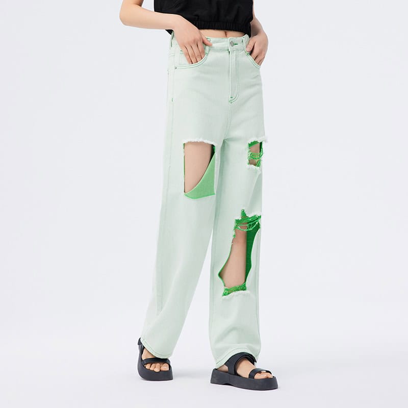 Bright green ripped high-waisted distressed jeans for women, fashionable denim with large holes, trendy streetwear style. Perfect for casual, fashion-forward looks.