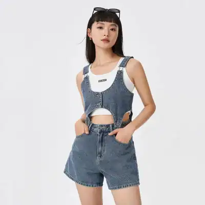 Stylish woman wearing trendy denim vest with cut-outs, paired with matching denim shorts, showcasing fashionable summer casual wear ideal for everyday outings.