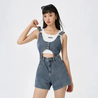 Stylish woman in denim crop top and high-waisted shorts showcasing trendy casual fashion and sunglasses. Perfect for summer and streetwear looks.