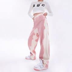 Stylish pink and white distressed wide-leg jeans paired with trendy white sneakers, perfect for casual chic looks. Comfortable and fashionable denim for everyday wear and street style.
