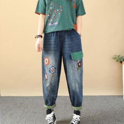 Casual denim jeans with colorful floral embroidery, relaxed fit, and oversized style. Perfect for trendy casual wear or street style fashion, featuring a patch pocket and rolled-up cuffs.