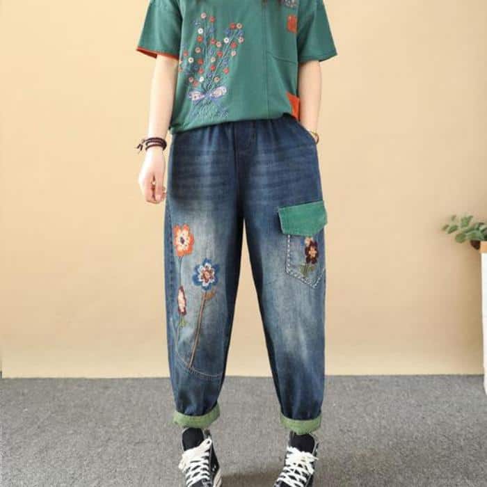 Casual denim jeans with colorful floral embroidery, relaxed fit, and oversized style. Perfect for trendy casual wear or street style fashion, featuring a patch pocket and rolled-up cuffs.
