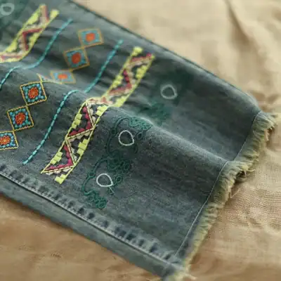 Brightly colored embroidered denim scarf featuring intricate patterns, perfect for adding a unique touch to fashion accessories and everyday outfits.