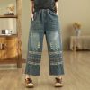 Comfortable distressed wide-leg denim pants with colorful embroidered patterns, casual and trendy style for everyday wear. Perfect for a fashionable, relaxed look.