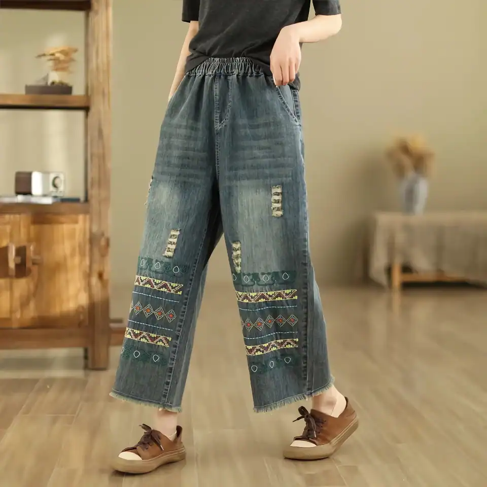 Comfortable wide-leg jeans with colorful embroidery and distressed details, perfect for everyday wear and casual outings.