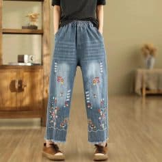 Stylish denim with colorful butterfly embroidery and distressed details, featuring an elastic waistband for comfort and relaxed fit, perfect for casual and trendy outfits.