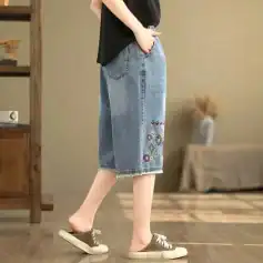 Stylish women's denim skirt featuring colorful embroidered patterns, relaxed fit, and frayed hem. Perfect for casual outings and trendy fashion statements.