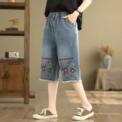Comfortable women's denim capris with colorful embroidery, elastic waistband, relaxed fit, perfect for casual wear and summer outings.