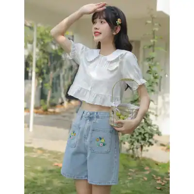 Modern casual fashion for women, trendy crop top and embroidered denim shorts perfect for warm weather and outdoor activities.