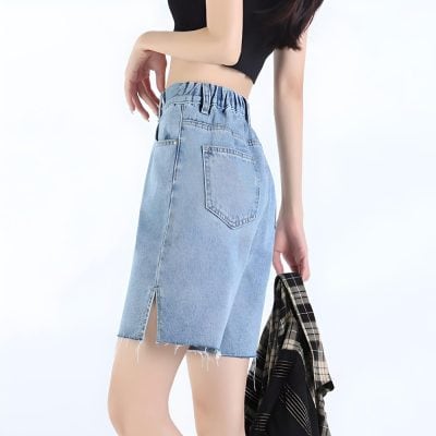 A stylish light-wash denim skirt with a high waist, front slit, and raw hem, perfect for casual and trendy outfits. Ideal for women looking for fashionable, comfortable, and versatile clothing.
