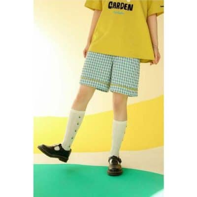 Bright yellow T-shirt paired with blue checkered shorts, knee-high socks, and black shoes. Perfect casual outfit for children, ideal for outdoor activities and warm weather.