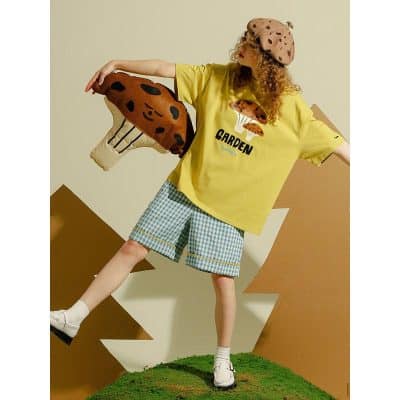 Colorful kids fashion with playful mushroom graphic t-shirt, checkered shorts, and fun accessories from Monalisa Store. Perfect for stylish children’s clothing needs.