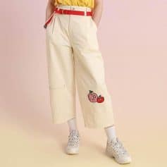 Playful cherry embroidery on cream wide-leg trousers with red belt accents, perfect for casual or trendy fashion statements.