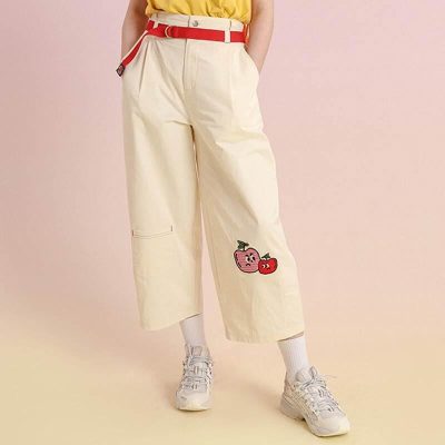 Playful cherry embroidery on cream wide-leg trousers with red belt accents, perfect for casual or trendy fashion statements.